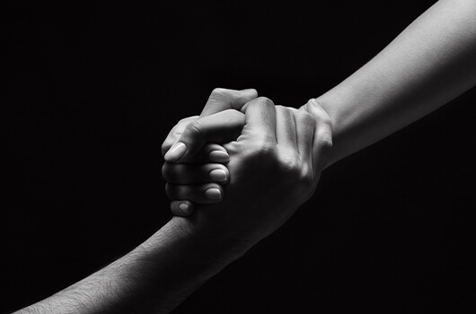 Photo of two people clasping hands together