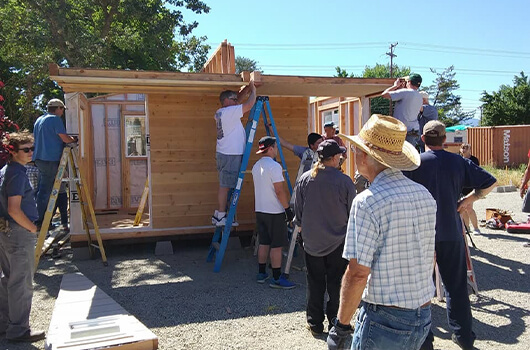 Photo of volunteers helping to build housing.